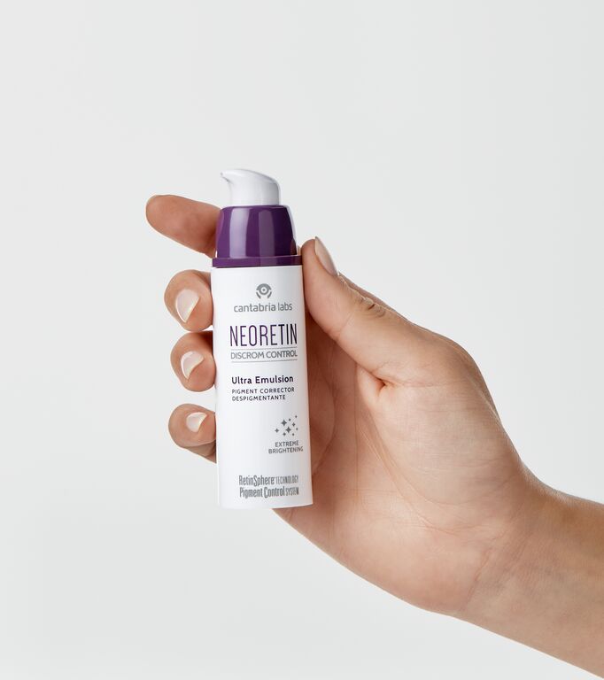 medium-neoretin_discrom-control-ultra-emulsion_packshot_grey-background_in-hand_2025